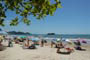 Crianças se divertindo na praia central de Balneário Camboriú e famílias tomando um sol na areira da praia.