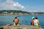 Pessoas relaxando em cima da pedra na Praia da Lagoinha em Bombinhas.