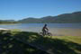 lagoa do peri, rapaz andando de bicicleta calmamente nas margens desta linda lagoa catarinense