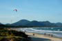 Barra da lagoa em floripa, pessoas fazendo um kite surf, outras caminhando calmamente nesta beleza de praia catarinense