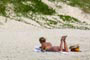 Gata tomando sol de biquini e lendo um bom livro na praia do siriu