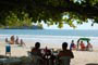 Pessoas tomando um cervejinha na beira da praia de itapema.