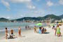 Praia de Itapema, turístas aproveitando um dia lindo de sol.