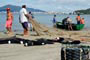 Pescadores tirando a rede do mar no canto da praia em itapema.