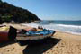 Barco de pesca e ao fundo dois pescadores em busca de um peixe.