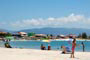 praia da pinheira, pessoas tomando sol e outras jogando frescobol